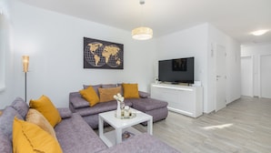 A modern living room with a grey sofa, a white coffee table, and a world map artwork on the wall. - Pendolina in Buje With 3 Bedrooms and 1 Bathrooms (Buje)