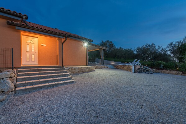 A house with a gravel driveway, a covered patio, and a bicycle parked outside. - Pendolina in Buje With 3 Bedrooms and 1 Bathrooms (Buje)