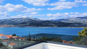 A coastal view with a clear sky, mountains in the background, and a body of water. - Sun Stone in Trogir With 4 Bedrooms and 4 Bathrooms (Trogir)