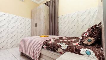 Un dormitorio con cama, armario de madera, cortina y pared con diseño de mármol.