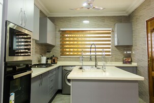 Cozinha moderna com forno embutido, micro-ondas e máquina de lavar louça.