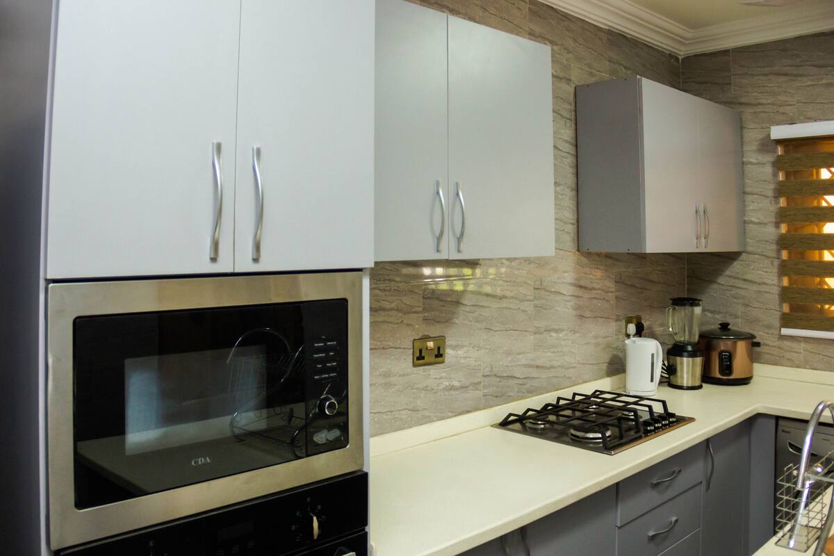 A modern kitchen with stainless steel appliances, a gas stove, and a built-in oven.