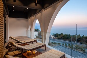 A balcony with lounge chairs and a table with a fruit bowl and a glass of orange juice. - Bura in Maru i i With 3 Bedrooms and 3 Bathrooms (Omis)