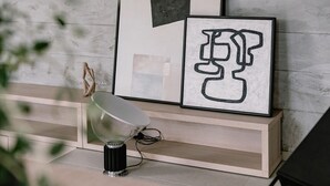 A modern interior with a white wooden floor, a black perforated wall, and a white shelf with framed artwork. - Domina in Vodice With 4 Bedrooms and 2 Bathrooms (Vodice)