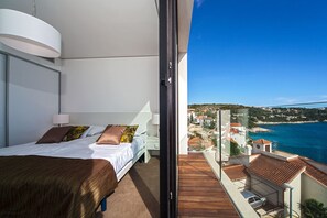 Un dormitorio con cama, mesita de noche y vistas a un pueblo costero.