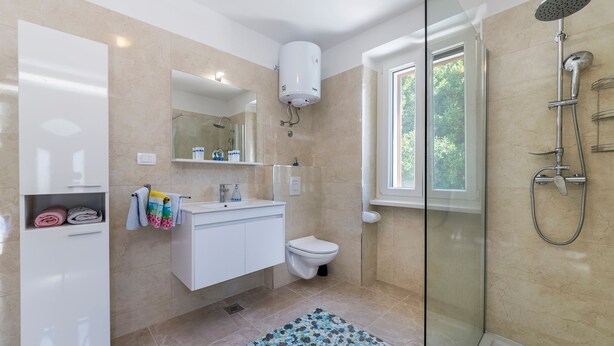 A modern bathroom with a glass shower enclosure, a toilet, a sink with a mirror, and a towel rack. - Ana Labin in Labin With 6 Bedrooms and 1 Bathrooms (Labin)