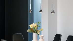 A conference table with six chairs, a vase with flowers, and pendant lights. - Calma II in Starigrad (Starigrad)