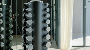 A modern gym with a central cylindrical structure holding multiple dumbbells. - Calma II in Starigrad (Starigrad)