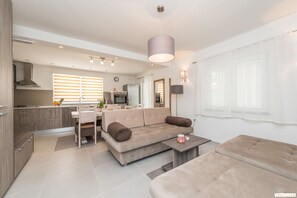 Ein modernes Wohnzimmer mit einer Couch, einem Couchtisch und einem Essbereich.