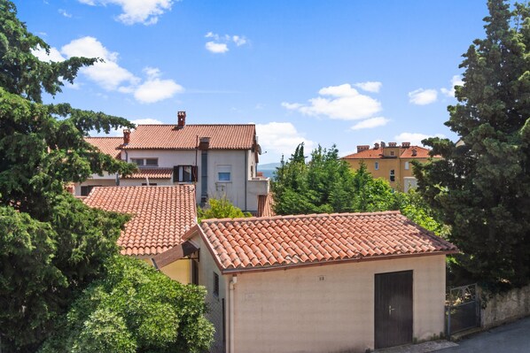 A residential area with terracotta-tiled roofs, surrounded by greenery and a clear blue sky. - Sea in Pula With 3 Bedrooms and 2 Bathrooms (Medulin)