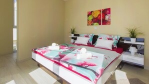 Un dormitorio con cama, mesita de noche, estante en la pared y dos plantas en macetas.