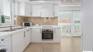 A modern kitchen with white cabinetry, a built-in oven, a microwave, and a sink. - Oliva in Premantura With 6 Bedrooms and 6 Bathrooms (Medulin)