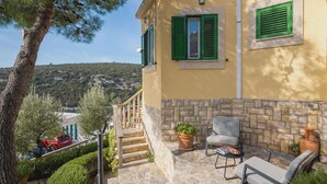 A yellow building with green shutters, a stone staircase, and outdoor seating with a table and chairs. - Vese in Ljubljeva With 3 Bedrooms and 2 Bathrooms (Marina)