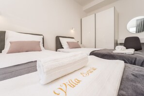 A hotel room with two beds, each with a pillow and a neatly folded towel. - Sarah in Vodice With 3 Bedrooms and 2 Bathrooms (Vodice)