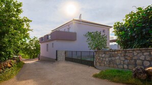 A single-story house with a paved driveway leading to a gated entrance. - Loki in Vi Inada With 4 Bedrooms and 4 Bathrooms (Vizinada)