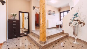 A hotel lobby with a marble staircase, a dark wooden dresser, and a large mirror. - Ines in Pula With 5 Bedrooms and 1 Bathrooms (Pula)