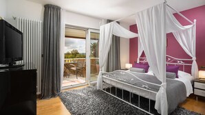 A bedroom with a four-poster bed, a television, and a balcony with a table and chairs. - Vlastelini I in Labin (Labin)