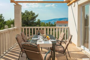 Varanda com mesa posta para o café da manhã, com vista para uma paisagem deslumbrante.