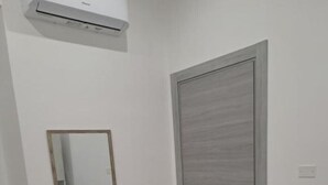A room with a bed, a wardrobe, a mirror, and an air conditioning unit. - Giorgia's House (Campofelice di Roccella)