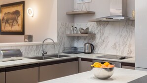 A modern kitchen with marble countertops, a sink, a toaster, and a bowl of fruit. - Design Sole in Svetvin Enat (Svetvincenat)