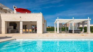 A swimming pool with a stone building and a pergola with a red umbrella. - Design Sole in Svetvin Enat (Svetvincenat)