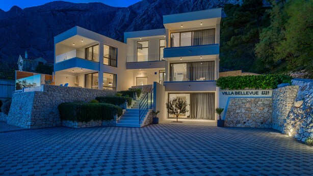 A modern villa with a stone facade, multiple balconies, and a paved entrance. - Bellevue in Bast Ba ka Voda (Baska Voda)