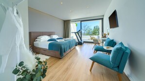 A modern hotel room with a large bed, a seating area, and a view of the outdoors. - Bellevue in Bast Ba ka Voda (Baska Voda)