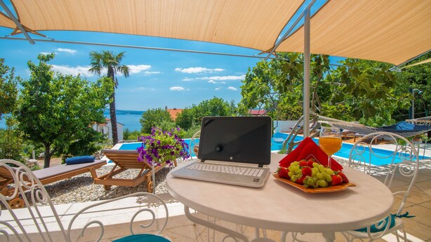 A terrace with a laptop, a fruit plate, and a glass of orange juice. - Organic Gardens in Crikvenica (Crikvenica)