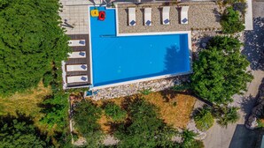 An aerial view of a swimming pool area with lounge chairs and a small poolside table. - Organic Gardens in Crikvenica (Crikvenica)