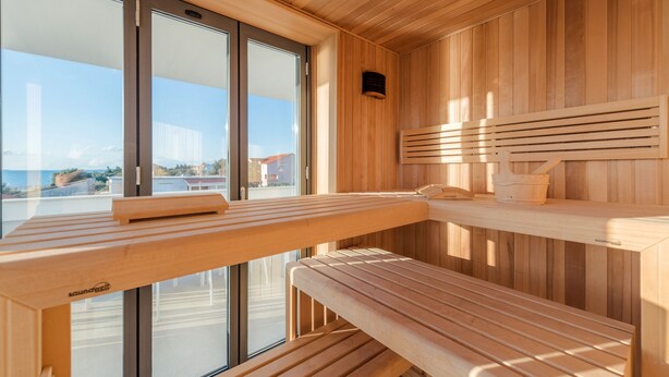 A sauna with wooden benches and a bench with a towel. - Four Seasons Vrsi in Vrsi (Vrsi)