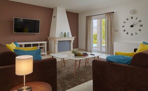 Una sala moderna con sofás marrones, una mesa de centro blanca, una chimenea y un reloj de pared grande.