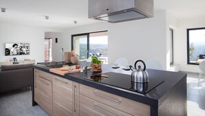 A modern kitchen with a large island, stainless steel appliances, and a view of the city. - Arsia in Labin With 4 Bedrooms and 4 Bathrooms (Rasa)
