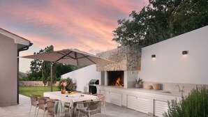 An outdoor patio with a dining table, chairs, and a grill. - Arsia in Labin With 4 Bedrooms and 4 Bathrooms (Rasa)