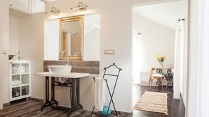 A modern bathroom with a large mirror, white sink, and a towel rack. - Makar in Makarska With 2 Bedrooms and 1 Bathrooms (Makarska)