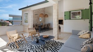 Un balcon spacieux comprenant un coin repas, des sièges et offrant une vue sur le paysage environnant.