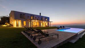 A modern house with a swimming pool, deck chairs, and a well-lit exterior. - Vista in Zamask With 3 Bedrooms and 3 Bathrooms (Pazin)