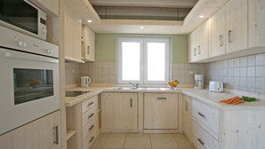 A kitchen with wooden cabinets, a double sink, and a built-in oven. - Bianca Pula in Pula With 8 Bedrooms and 4 Bathrooms (Medulin)