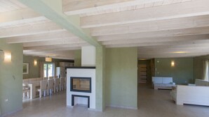 A spacious living area with a fireplace, a dining table with chairs, and a sofa. - Bianca Pula in Pula With 8 Bedrooms and 4 Bathrooms (Medulin)