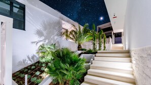Un edificio moderno con una escalera, paredes blancas y plantas verdes.
