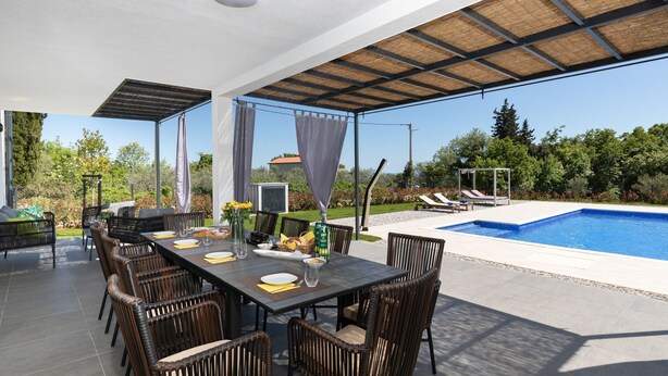 An outdoor dining area with a pool and a covered patio. - Dolce Bacio in Kavran (Marcana)