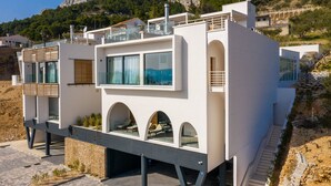 A modern, two-story building with a balcony, large windows, and a unique architectural design. - Complex Wind Rose in Maru i i (Omis)