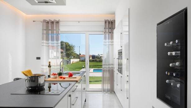 Una cocina moderna con vistas a una piscina y jardín.