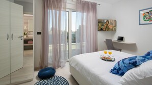 Una habitación de hotel moderna con una cama, un escritorio y vistas a la ciudad.