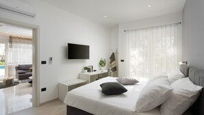 Une chambre moderne avec un grand lit, un téléviseur à écran plat, un bureau et une vue sur un balcon.