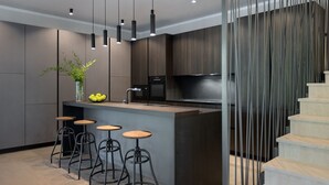 A modern kitchen with a central island, bar stools, a refrigerator, and a microwave. - Viktor in Kr an With 7 Bedrooms and 7 Bathrooms (Krsan)