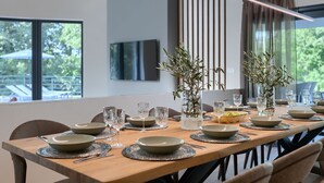 A dining table set with plates, glasses, and a vase with dried plants. - Viktor in Kr an With 7 Bedrooms and 7 Bathrooms (Krsan)