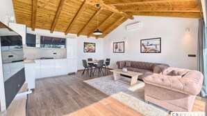 A modern kitchen with white cabinets, a dining area with a brown sofa, and a wooden ceiling. - Filip in Murter With 4 Bedrooms and 2 Bathrooms (Tisno)
