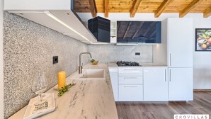 A modern kitchen with granite countertops, white cabinetry, and a wooden ceiling. - Filip in Murter With 4 Bedrooms and 2 Bathrooms (Tisno)