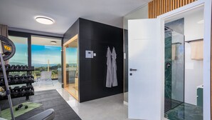 Uma academia moderna com equipamentos de exercício, um banco e vista para o exterior.