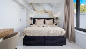 Quarto moderno com cama, mesas de cabeceira, escrivaninha e janela com cortinas.